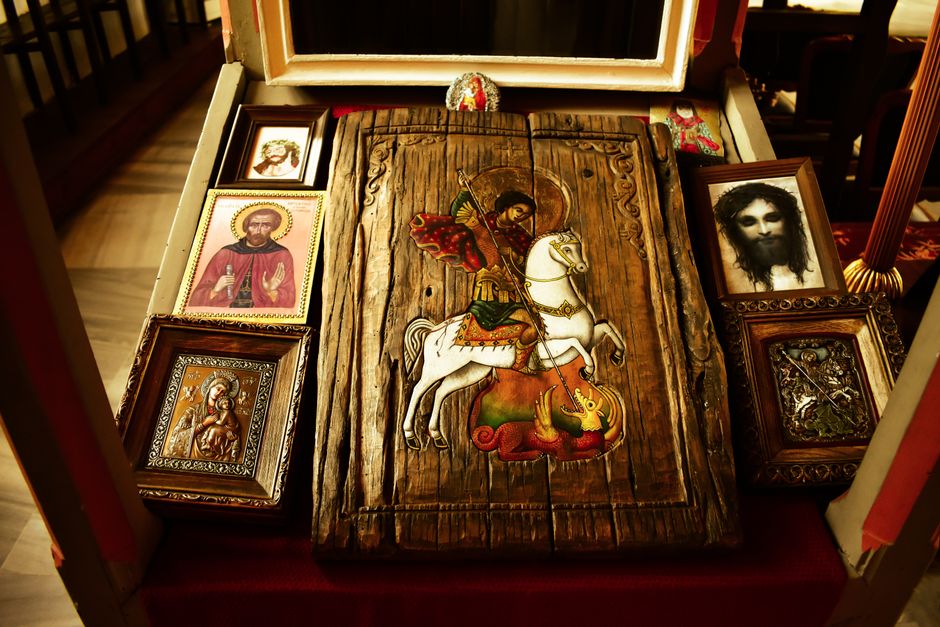 A collection of religious wood carvings and paintings displayed indoors.