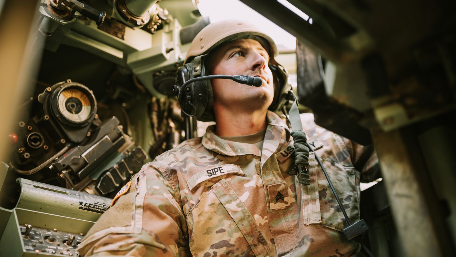 Modafinil for Military Personnel: Enhancing Performance A soldier in camouflage uniform inside an armored vehicle, looking focused — modafinil for military personnel