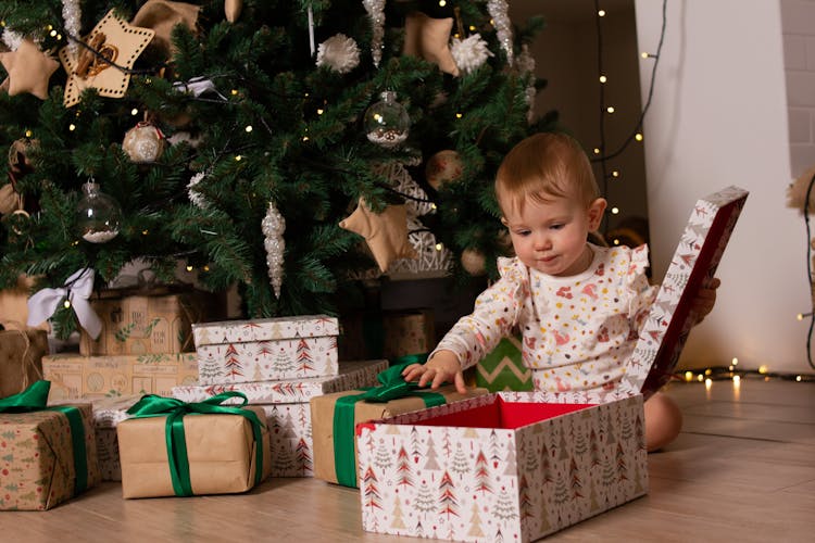 A Cute Baby Opening A Christmas Present