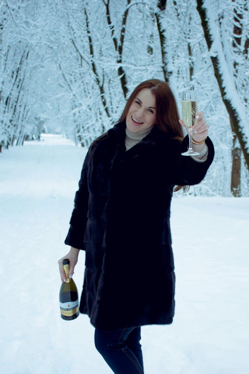 Woman in Black Coat Holding Champagne Glass