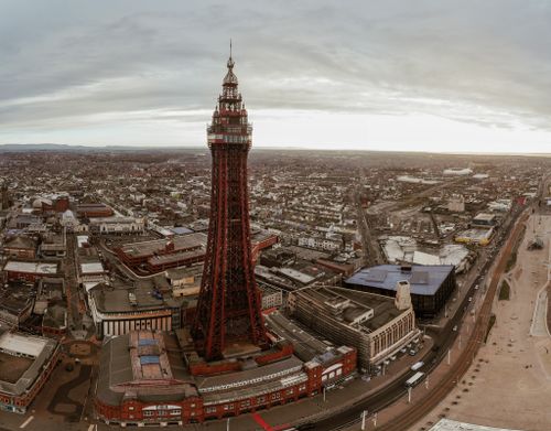 Free Aerial view of the iconic Blackpool Tower in England, capturing the surrounding urban landscape. Stock Photo