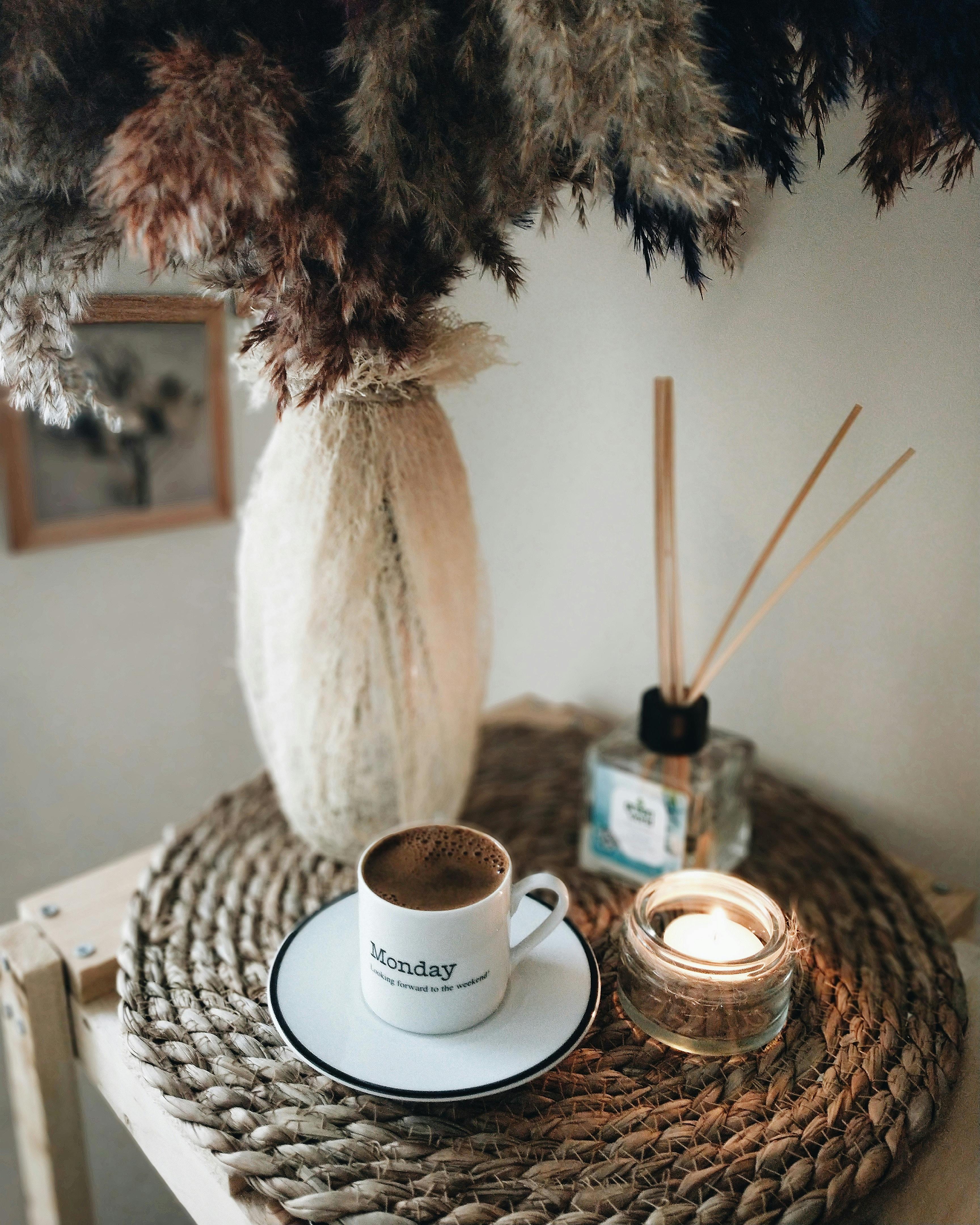 Free Coffee next to Candle and Vase Stock Photo