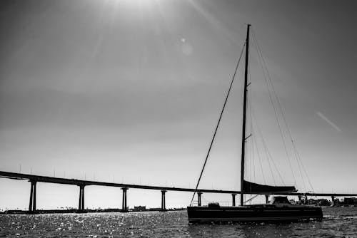 Grayscale Photo of Sail Boat on Sea