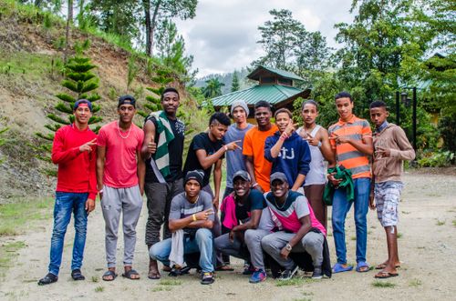 Free A group of young men poses outdoors with casual, colorful attire in a natural setting. Stock Photo