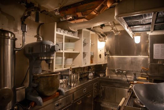 Cozy industrial kitchen with vintage equipment and stainless steel surfaces, perfect for culinary nostalgia.