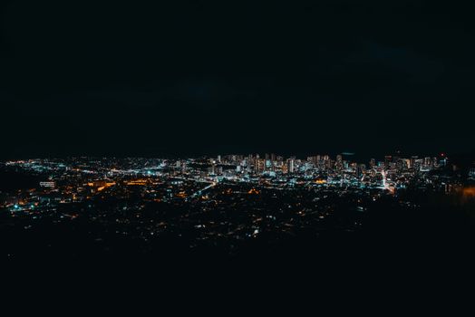 A breathtaking aerial view of a city skyline glowing with lights under a dark night sky.