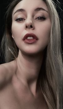 Close-up portrait of a blonde woman with striking red lipstick, showcasing beauty and elegance.