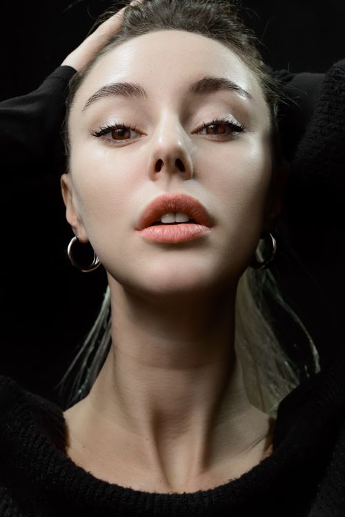 Free Close-up portrait focusing on the elegant features of a woman with natural makeup. Stock Photo