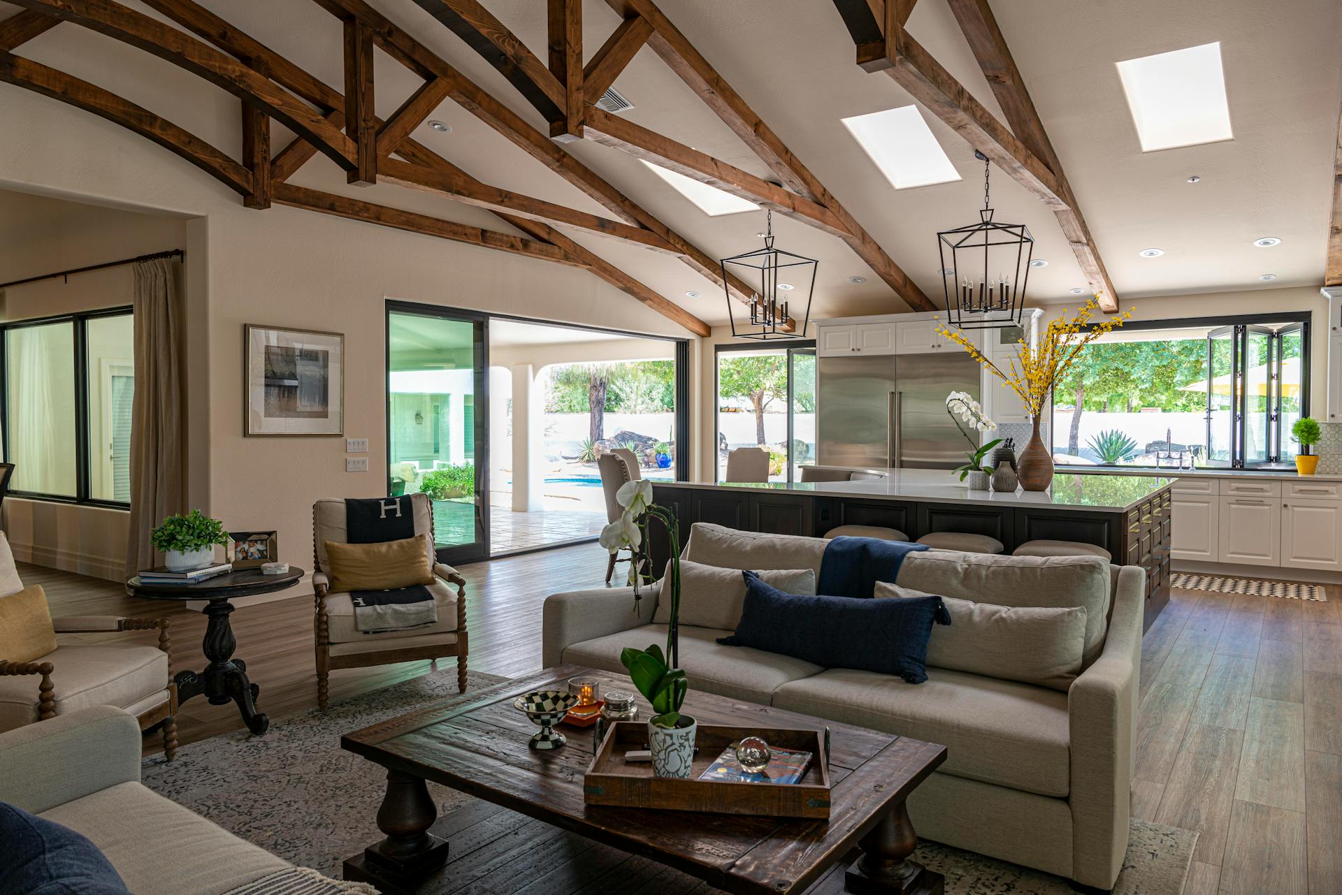 Elegant open-plan living room and kitchen with wooden beams and contemporary design elements.