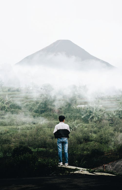 Free Man Looking at the Mountains with a Lot of Fog Stock Photo