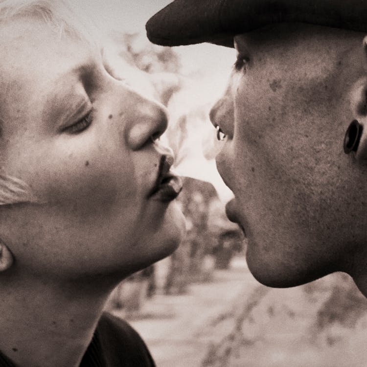 Woman Blowing Smoke On Man's Mouth 