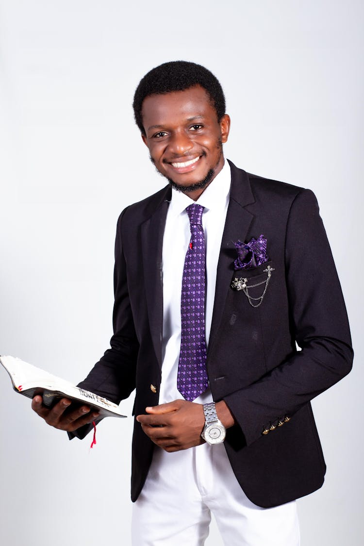 Man In Black Suit Jacket Holding A Book