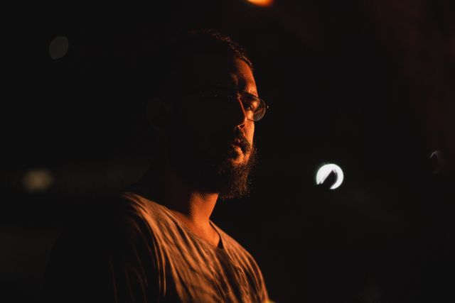 A low-light portrait of a bearded man against a dark background — photo by Nathan Marcam on Pexels