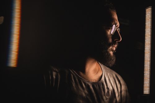 Free Dramatic side profile of a bearded man wearing eyeglasses in dim lighting. Stock Photo