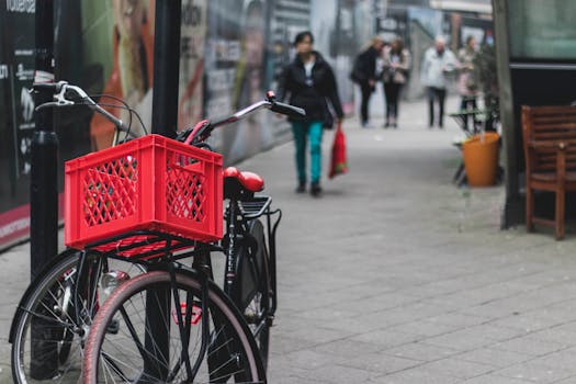 Bicycles parked on a pavement with pedestrians in Rotterdam, Netherlands.