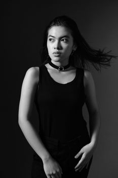 Striking black-and-white portrait of a fashionable woman posing in a studio.