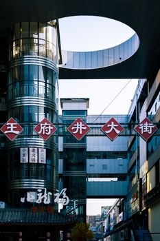 Contemporary city street featuring modern architecture with traditional Chinese symbols.