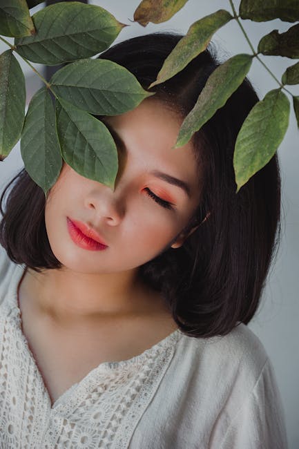 A serene portrait of a woman surrounded by leaves, showcasing beauty and nature.