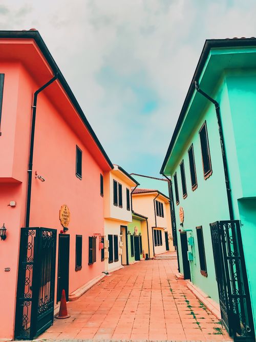 Free Vibrant alleyway featuring colorful building facades under a bright sky. Stock Photo