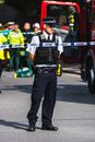 Police officer standing behind a Barricade Tape