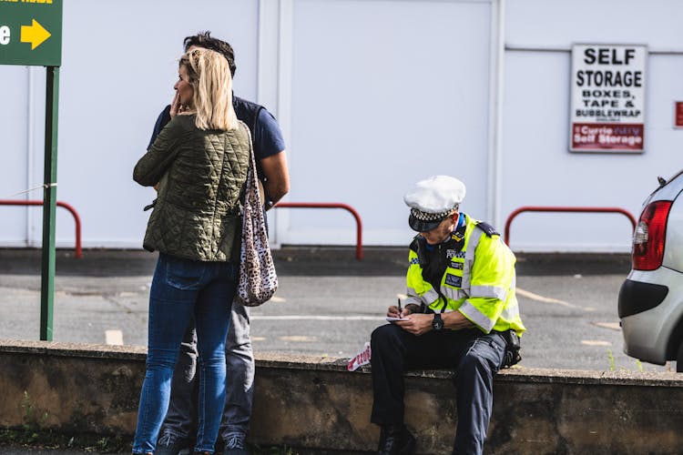 Police Office Sitting On Wall And Writing