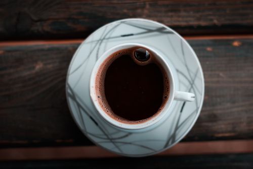 Free Aerial view of a hot coffee in a vintage porcelain cup on a wooden table. Stock Photo