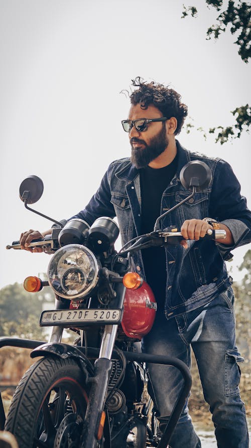 Free Bearded Man Holding a Motorcycle Stock Photo