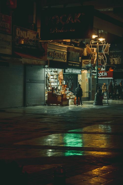 Free A cozy street shop illuminated at night, offering a glimpse into urban nightlife. Stock Photo