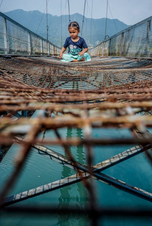 Young Girl sitting on Metal Fences