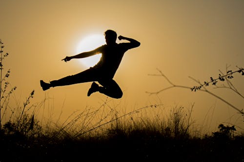 Silhouet Van De Mens Die Kick Sprong Doet Tijdens Zonsondergang