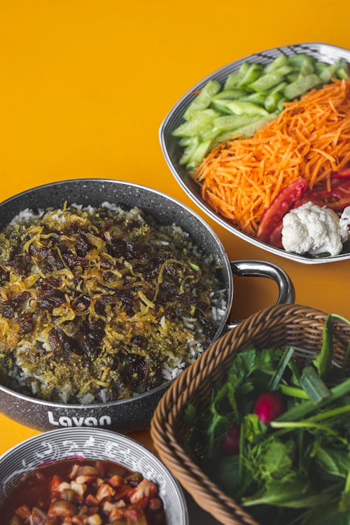 Cooked Food in Cooking Pot Beside Vegetables in Bowls and Basket