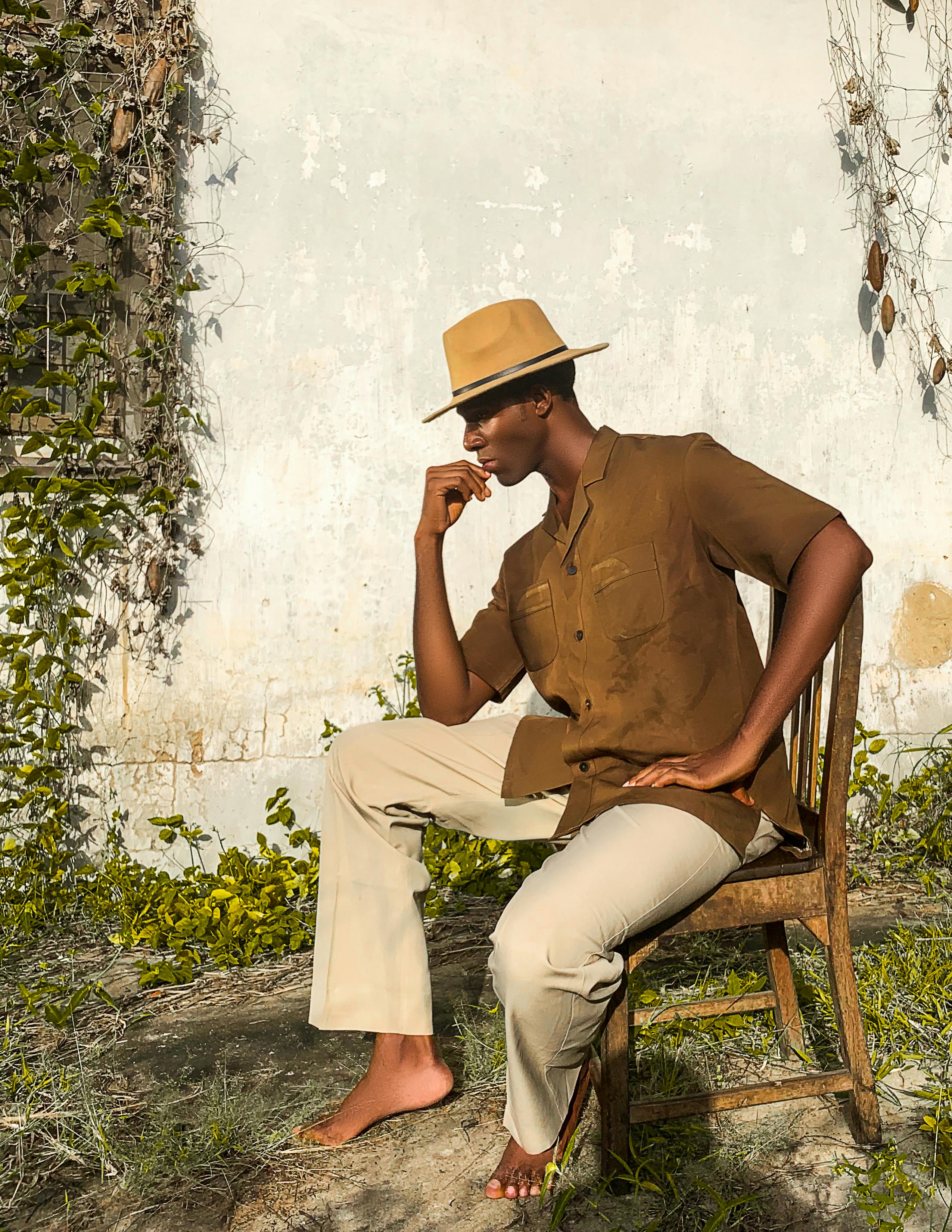 De franc Home Amb Camisa Marró Amb Botons Assegut En Una Cadira De Fusta  Foto d'estoc