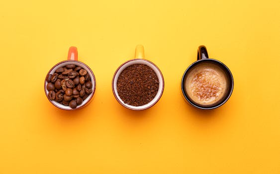 Three stages of coffee displayed on cups resting on a vibrant yellow surface.