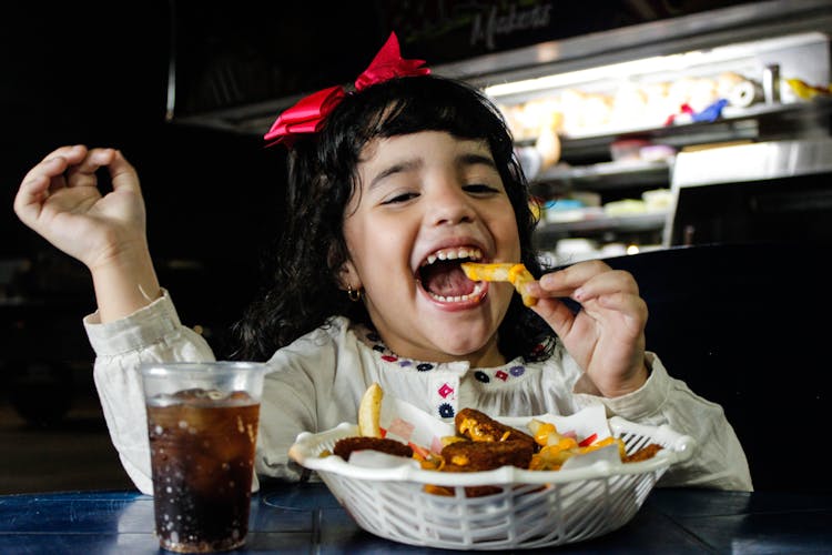 Photo Of A Girl Eating Fries