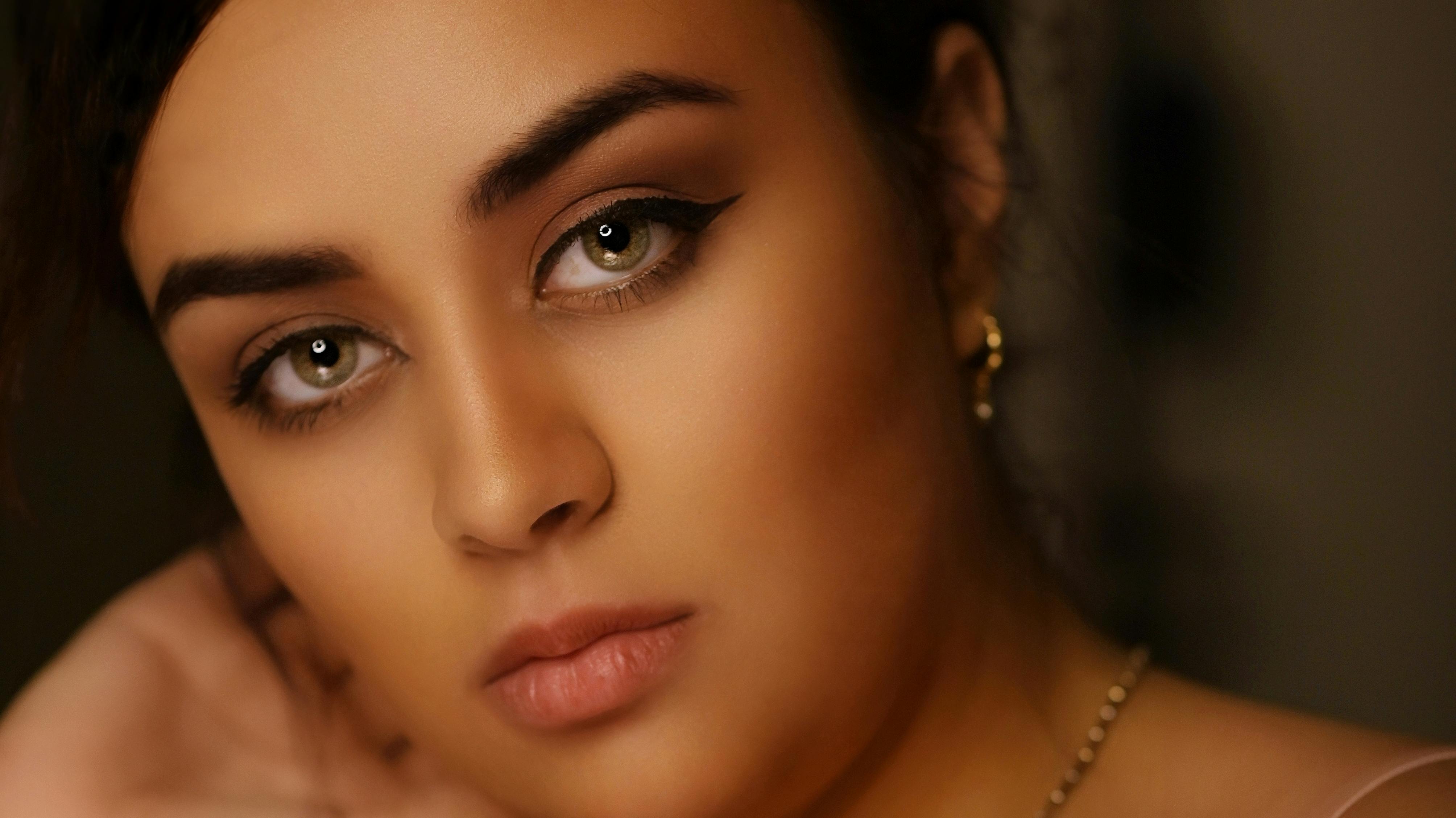 A close-up portrait showcasing a woman's elegant makeup and serene expression.