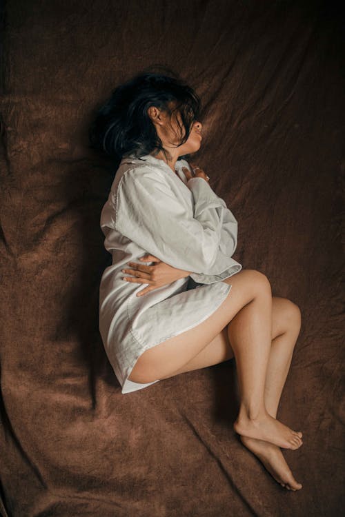 Woman in Shirt Lying on Bed 