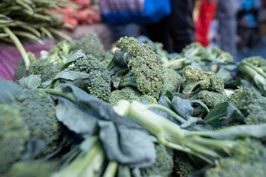Close-up of vibrant green broccoli displayed at a bustling outdoor market.