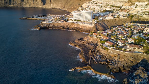 Aerial photograph showing the coastline of Santiago del Teide, Spain, highlighting rocky shorelines and residential areas.