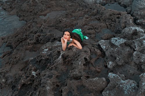Woman Lying on the Rocky Beach 