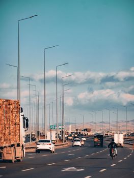Highway scene with trucks and cars under a clear blue sky, highlighting modern transportation.