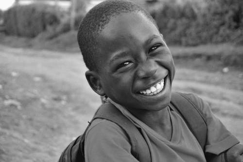 Grayscale Photo of a Boy Smiling