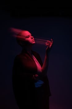 A creative portrait of a woman with blurred motion and red lighting effects in a studio setting.