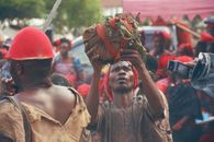A cultural event in Ghana featuring a traditional ritual with people gathered in vibrant attire.