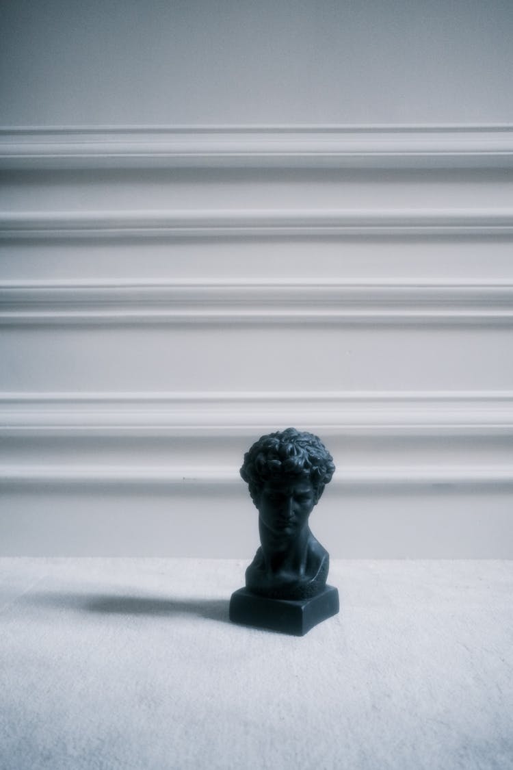 A Black Colored Sculpture Of A Man's Head