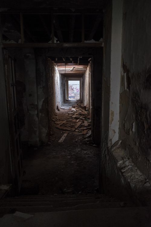Free Eerie abandoned hallway with scattered debris, evoking a sense of mystery and decay. Stock Photo