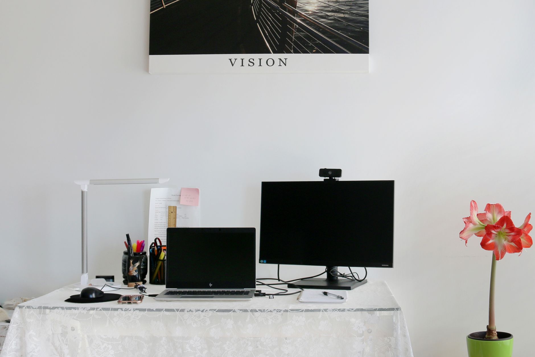 Stylish home office with laptop, monitor, and modern decor on a white desk.