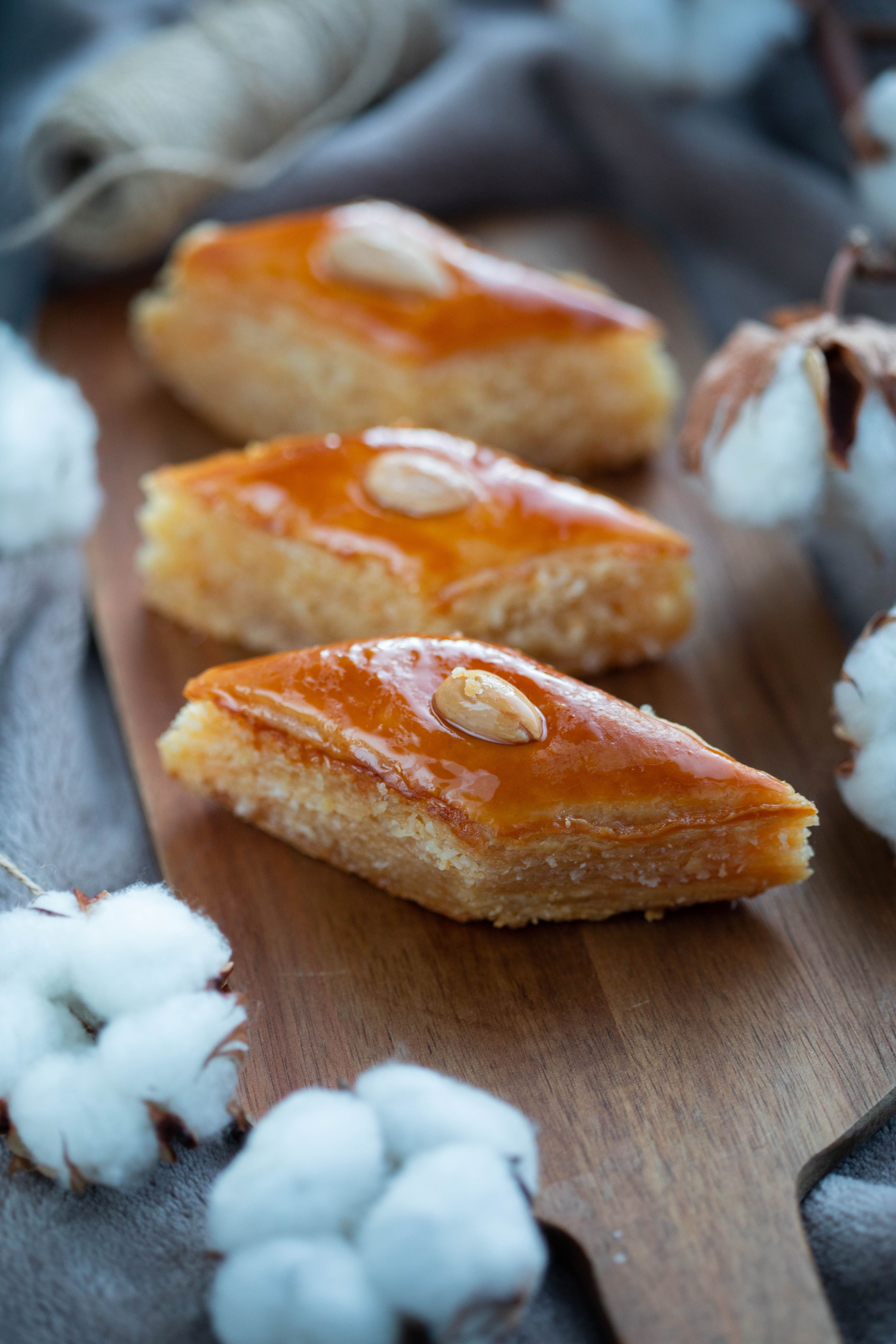 Close-up of Turkish baklava with almonds on wooden trays. Mouth-watering dessert shot.