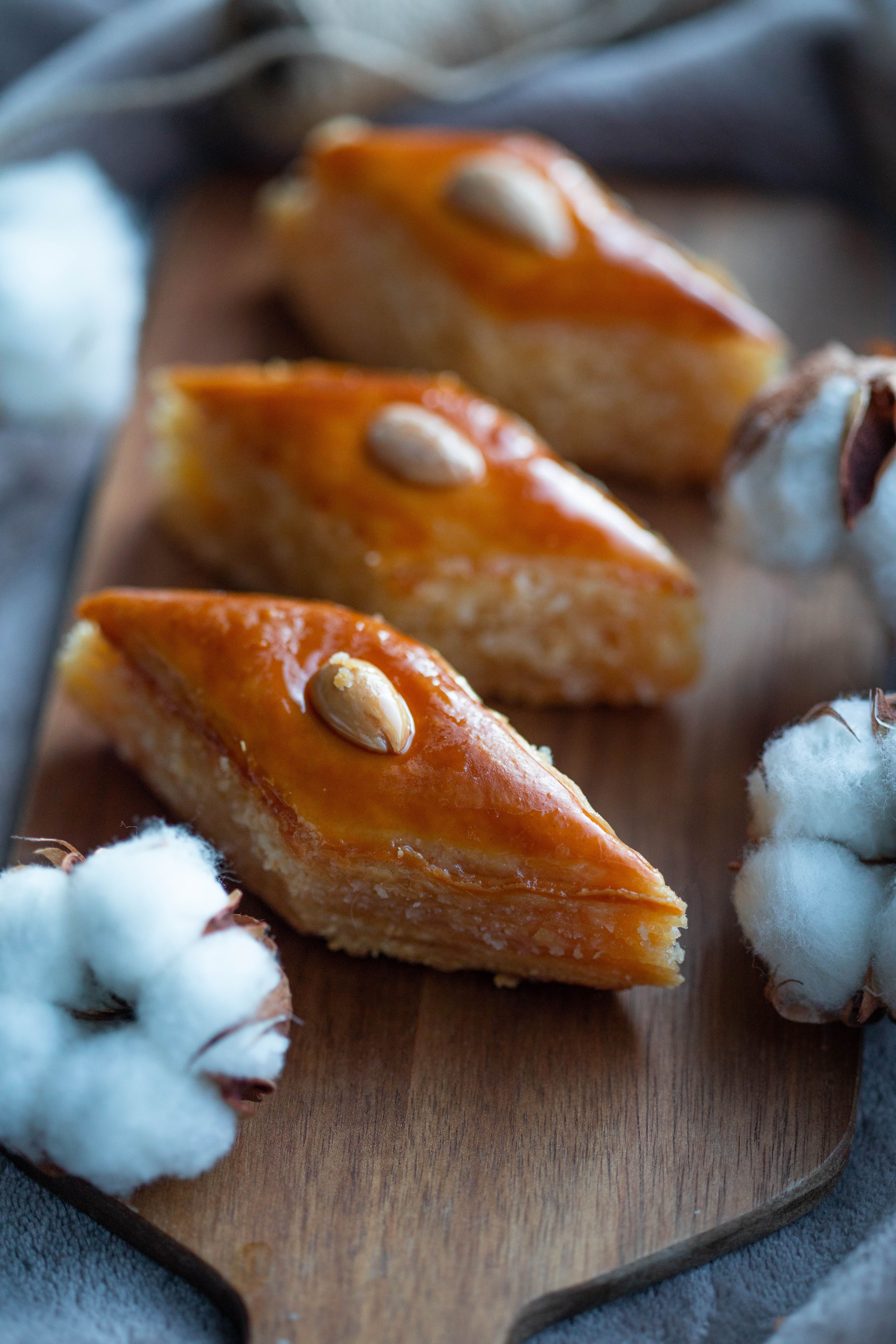 Close-up of freshly baked baklava with almonds, beautifully presented on a wooden board.