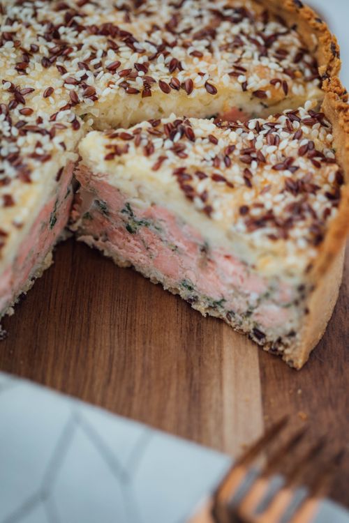 Free Close-up of a homemade savory pie with seeds on a wooden board, showcasing freshness and texture. Stock Photo