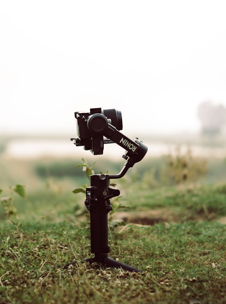 Black Camera On Stabilizer On Green Grass 